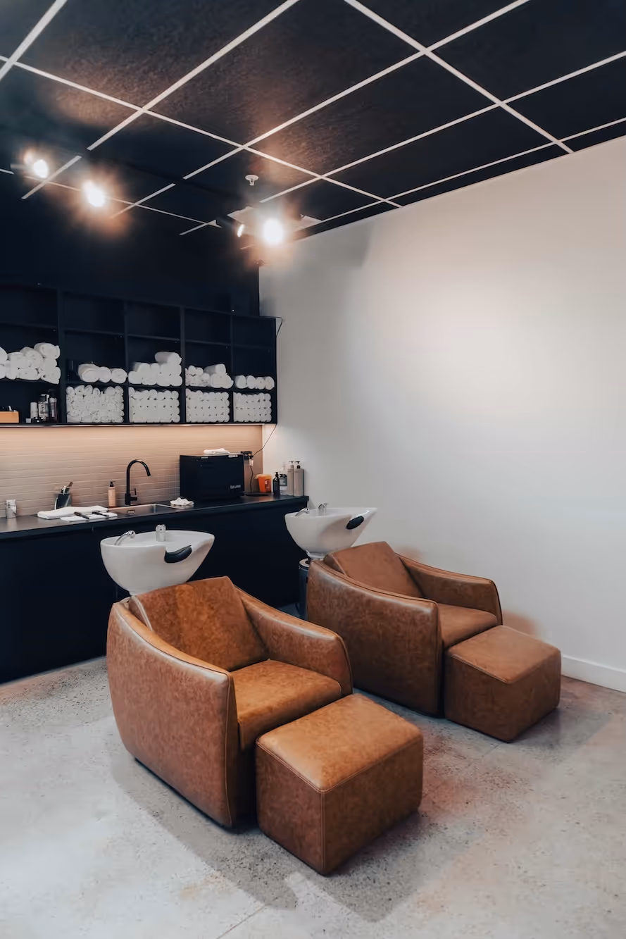 The barbershop area with a leather sofa, ready for clients.
