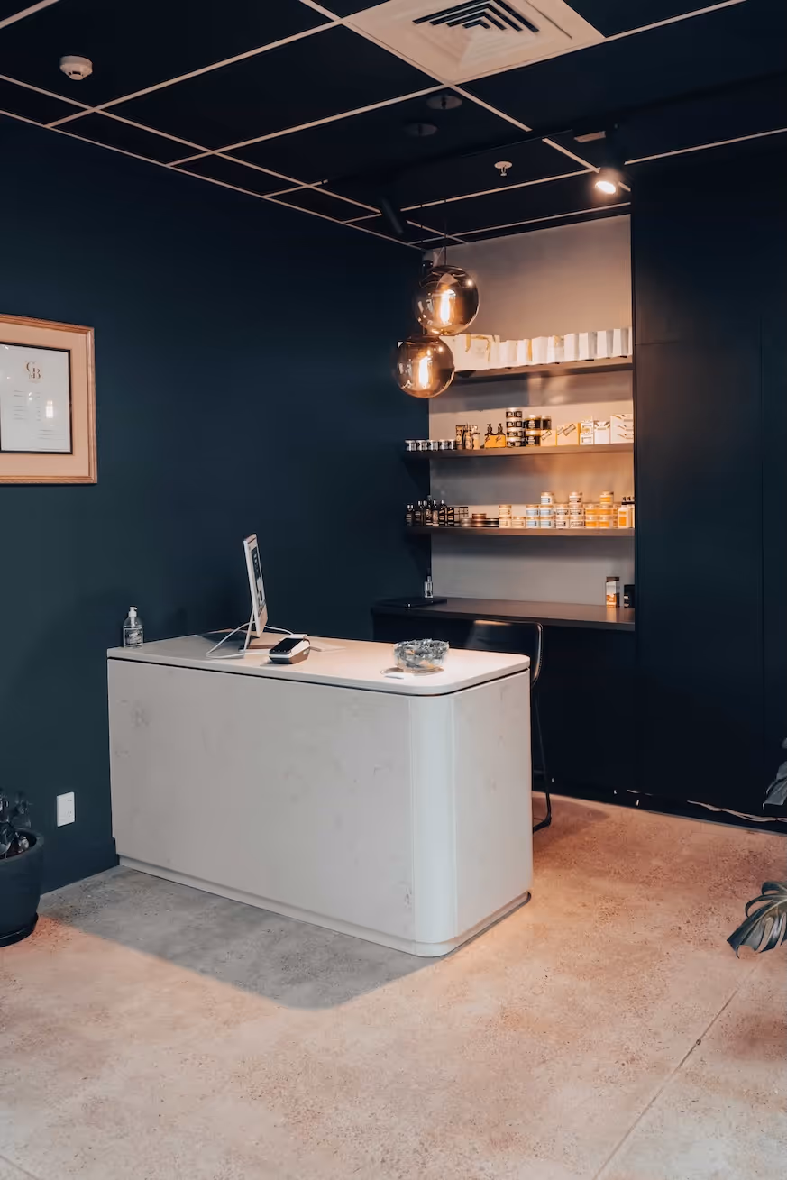 A modern, clean barber station with a white sink and marble countertop at Gentry & Blade Barbershop.