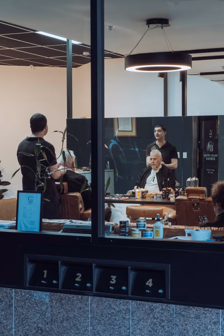 A view of the stylish barber chairs from the exterior, showcasing the shop's elegant interior.
