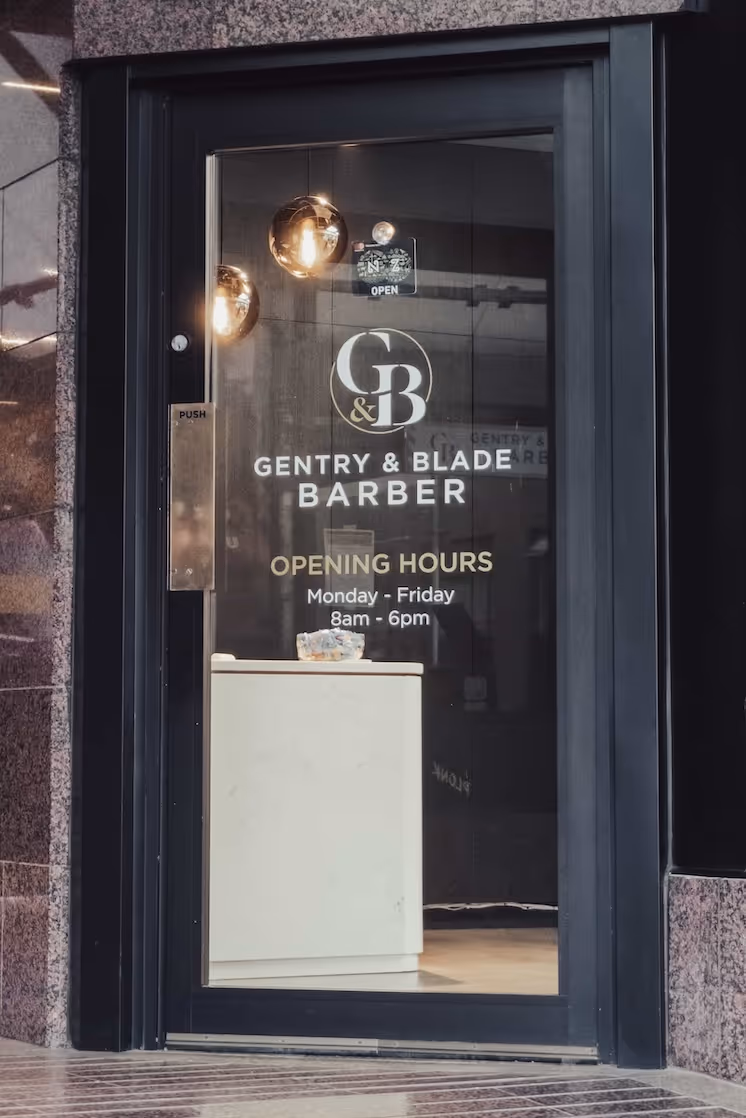 The Gentry & Blade Barber logo and entrance on a glass door on Customhouse Quay, Wellington.
